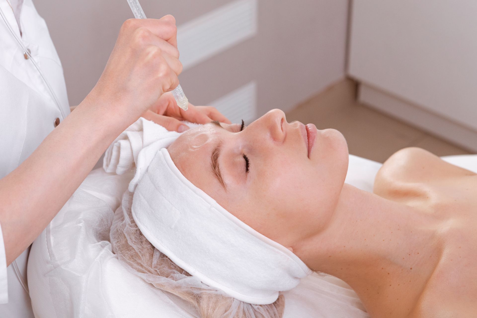 A woman is getting a facial treatment at a beauty salon.