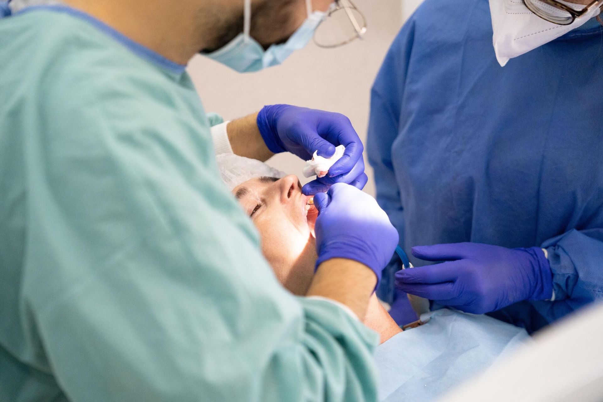 A dentist is examining a patient 's teeth in a dental office.