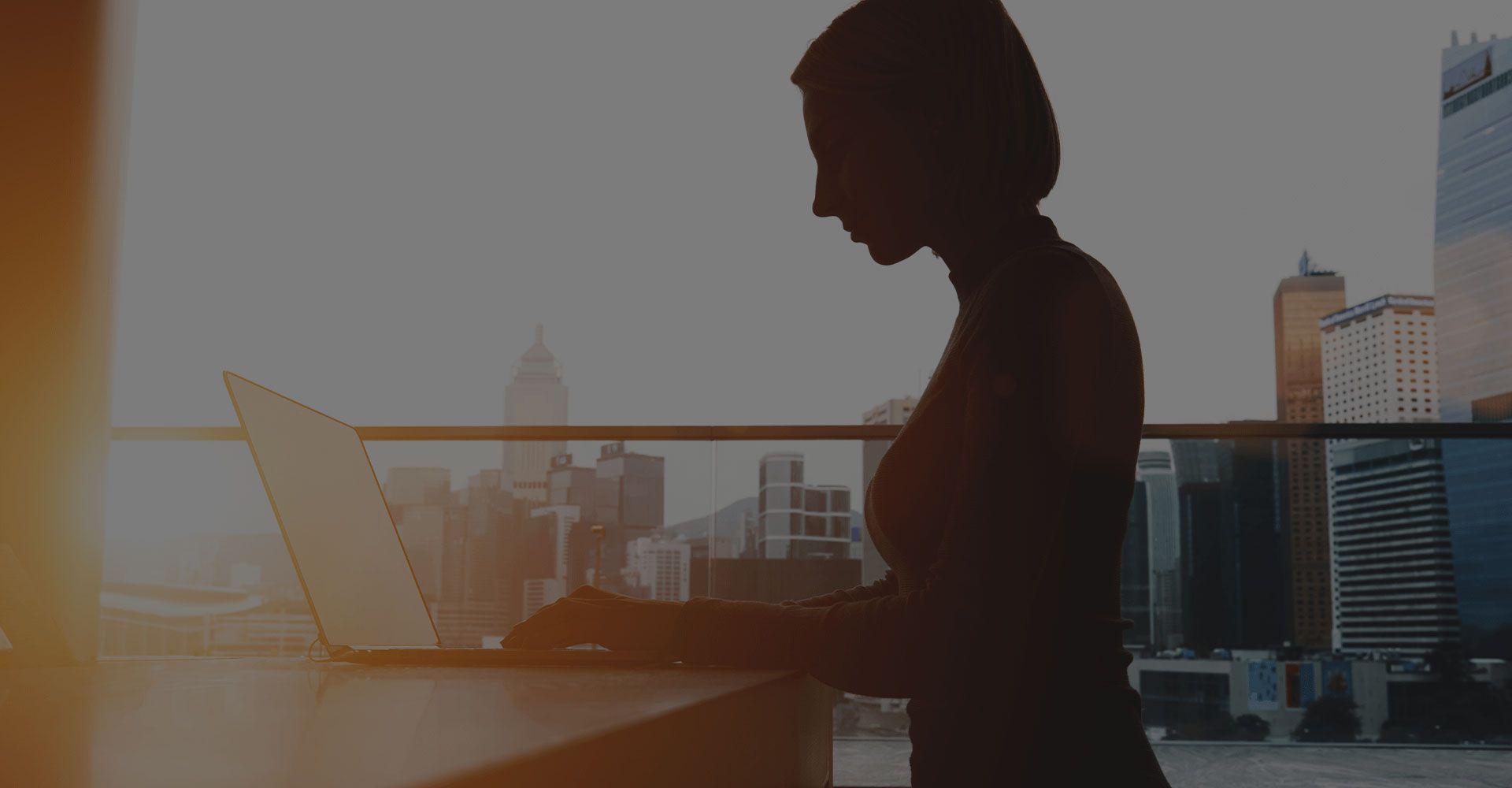 A woman is sitting at a table using a laptop computer.