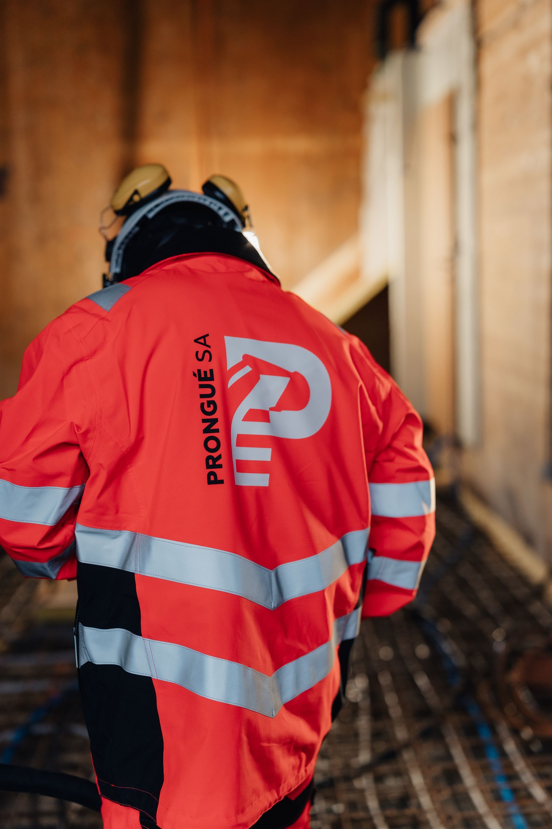 Un ouvrier portant une veste de sécurité rouge Prowise traverse un tunnel.
