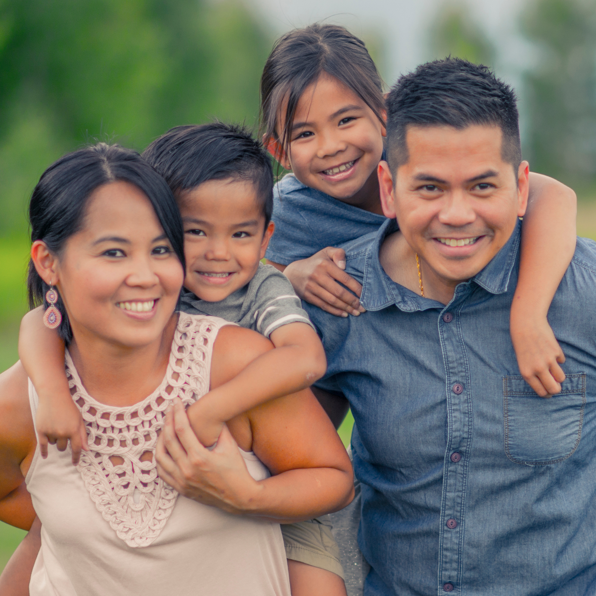 A family is posing for a picture together and smiling for the camera.
