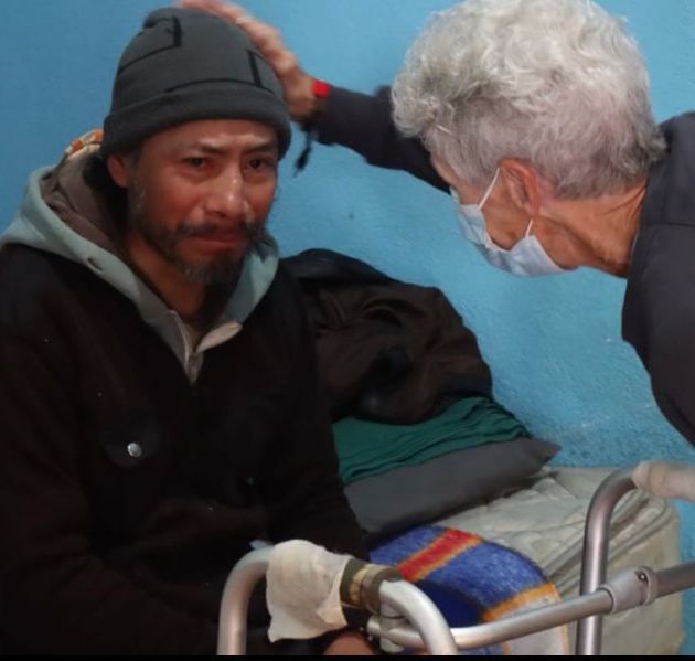 Nurse Nancy praying with a this man after giving him much-needed care for an infection