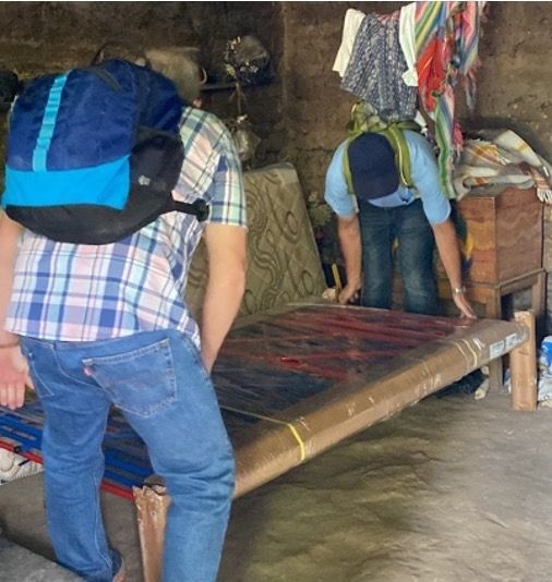 Two missionaries installing a bed for a poor elderly Guatemalan woman. 