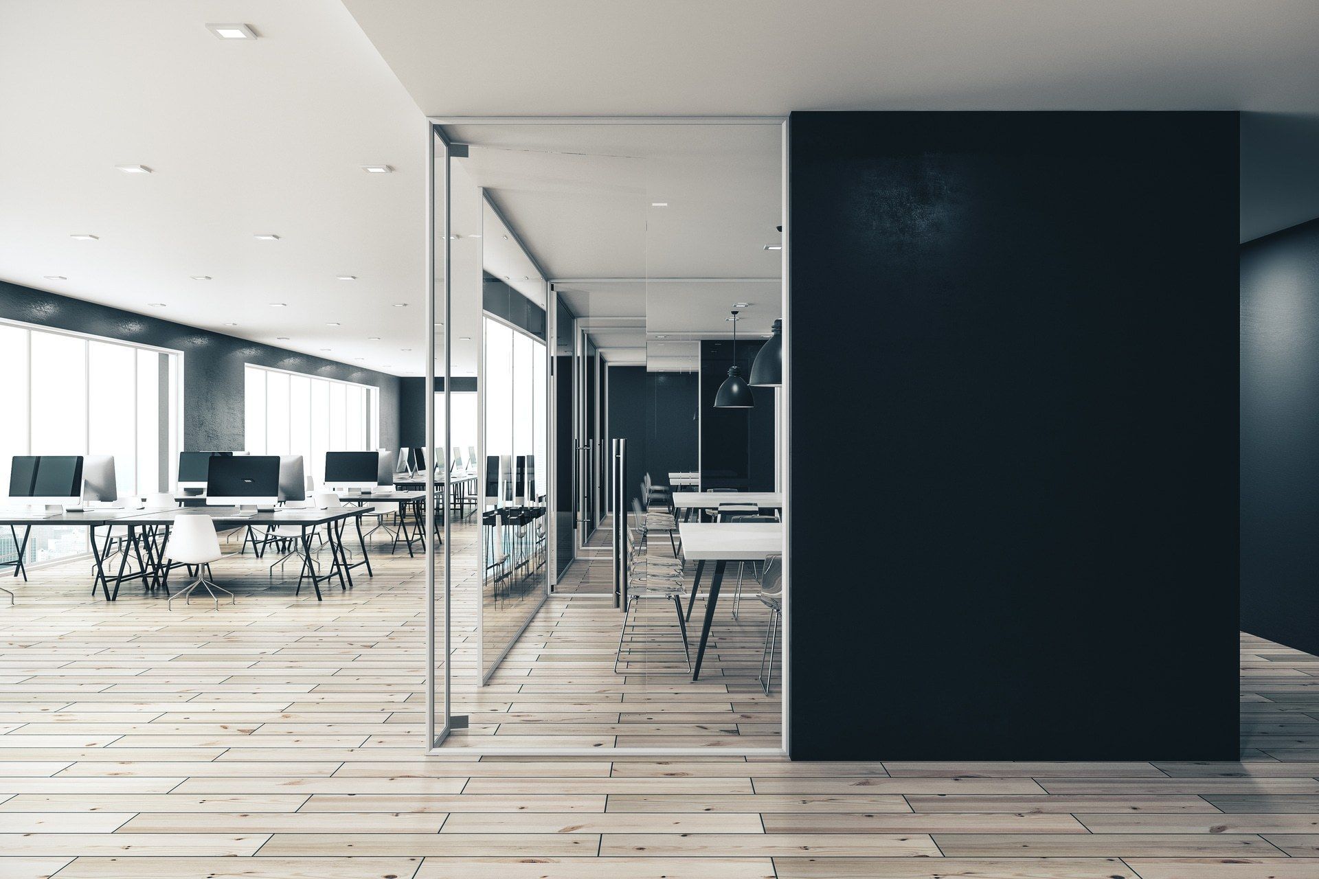 An empty office with wooden floors and a glass wall.