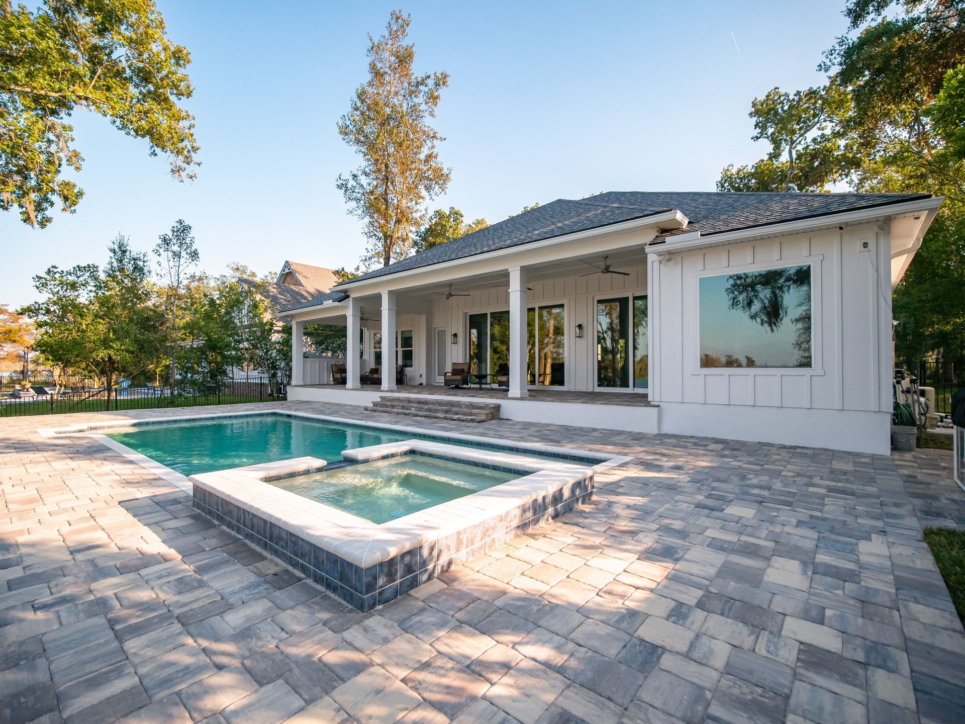 A white modern house with a patio, swimming pool.