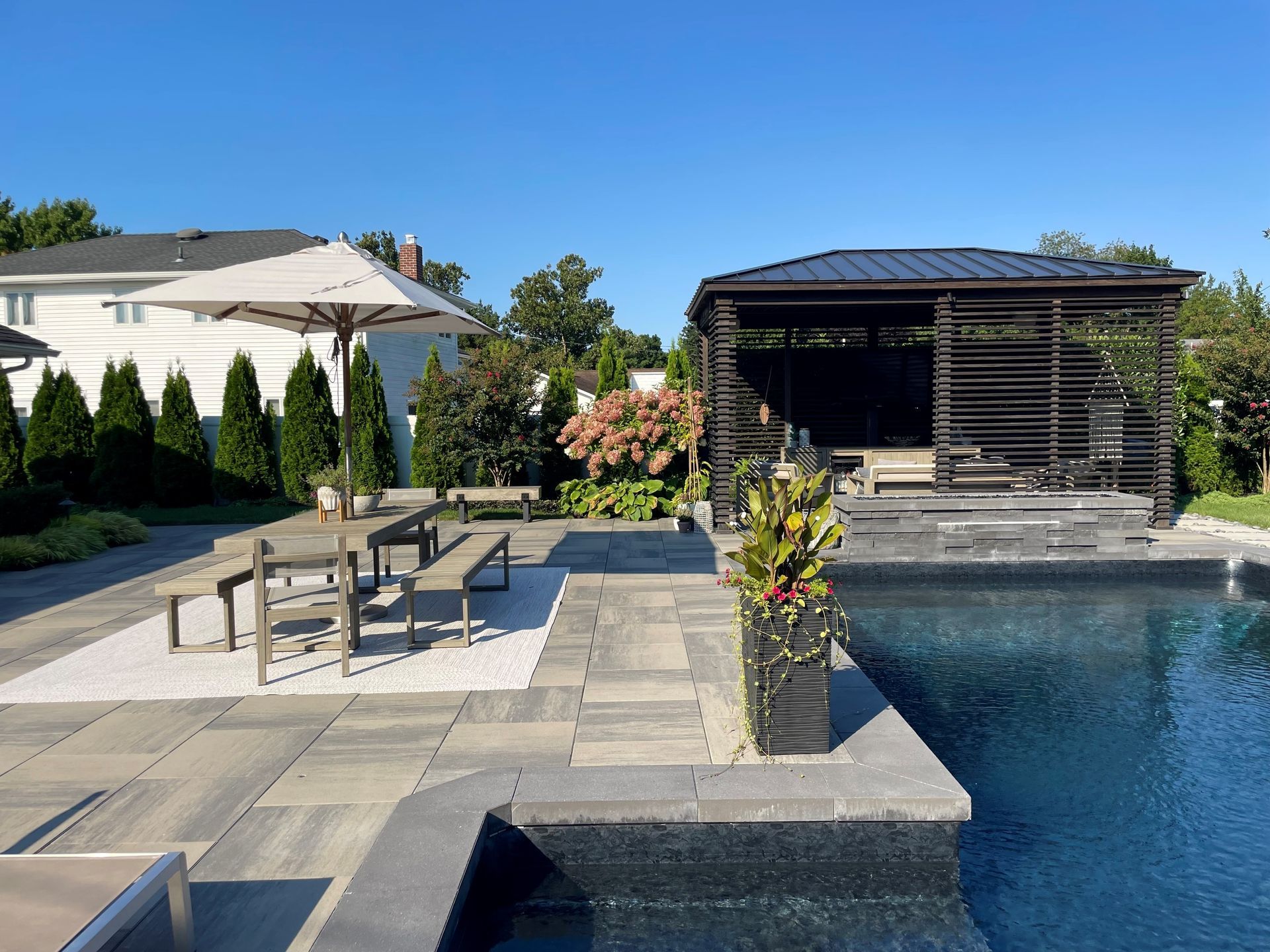 A backyard pool area with a covered patio.
