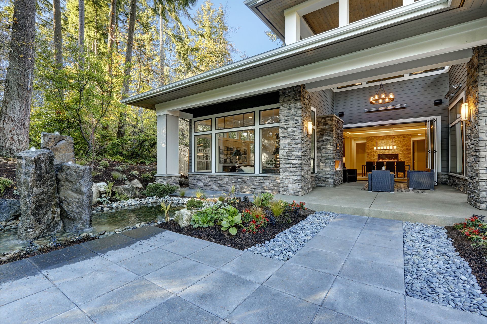 A covered stone patio with a gray paver walkway.