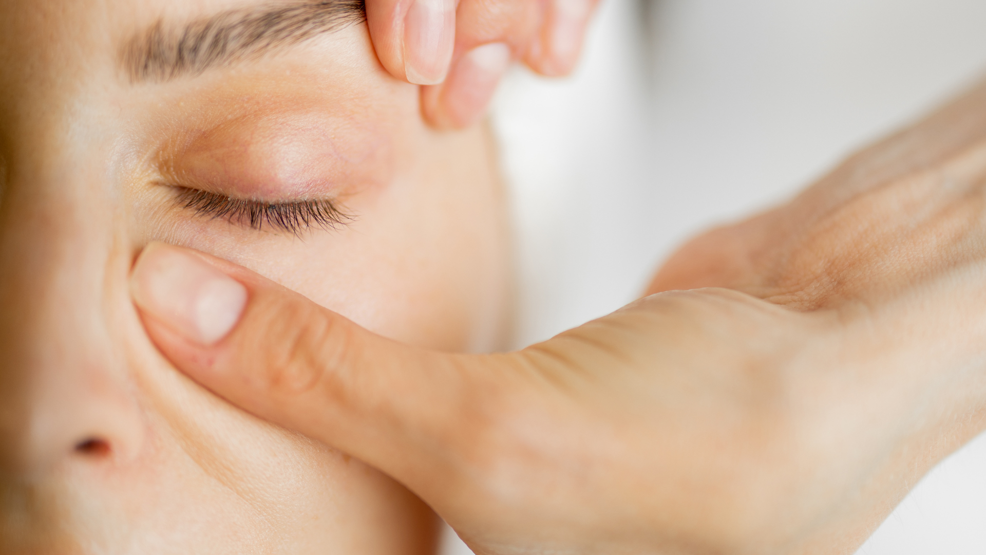 A close up of a woman 's face with her hand on it.