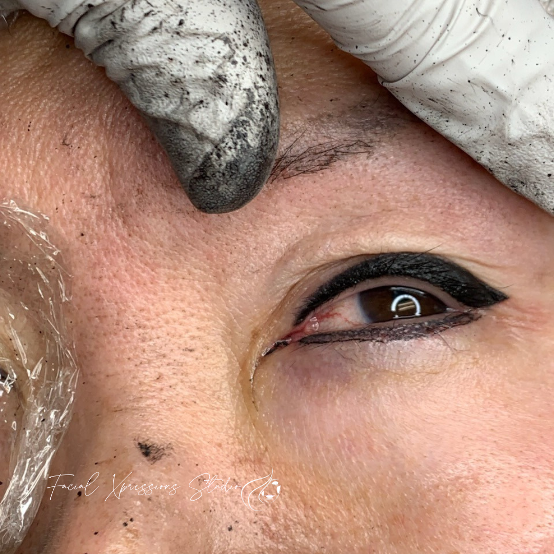 A close up of a woman 's eye with a tattoo on it.