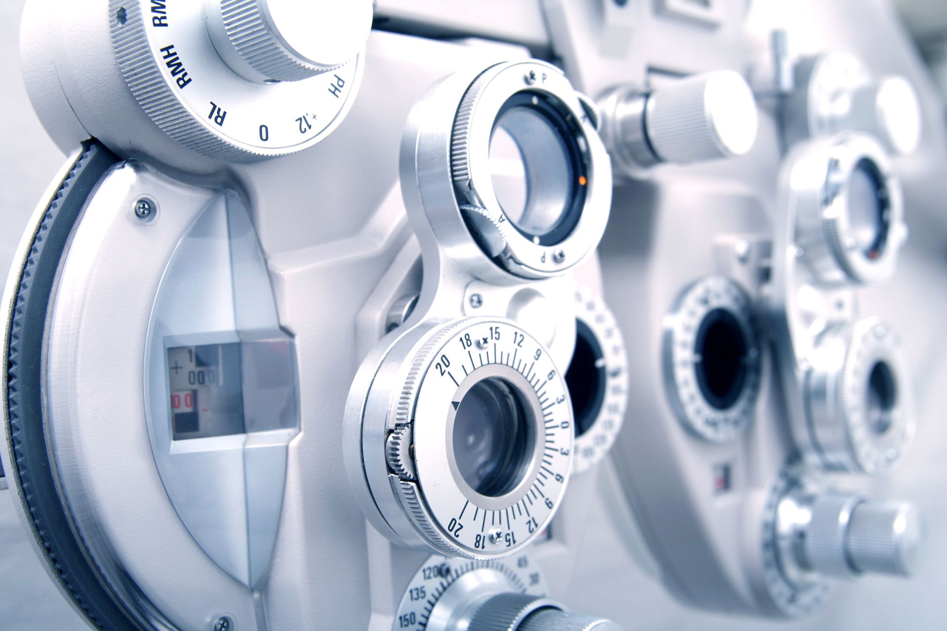 Close-up of a white ophthalmology phoropter with dials and lenses for vision testing