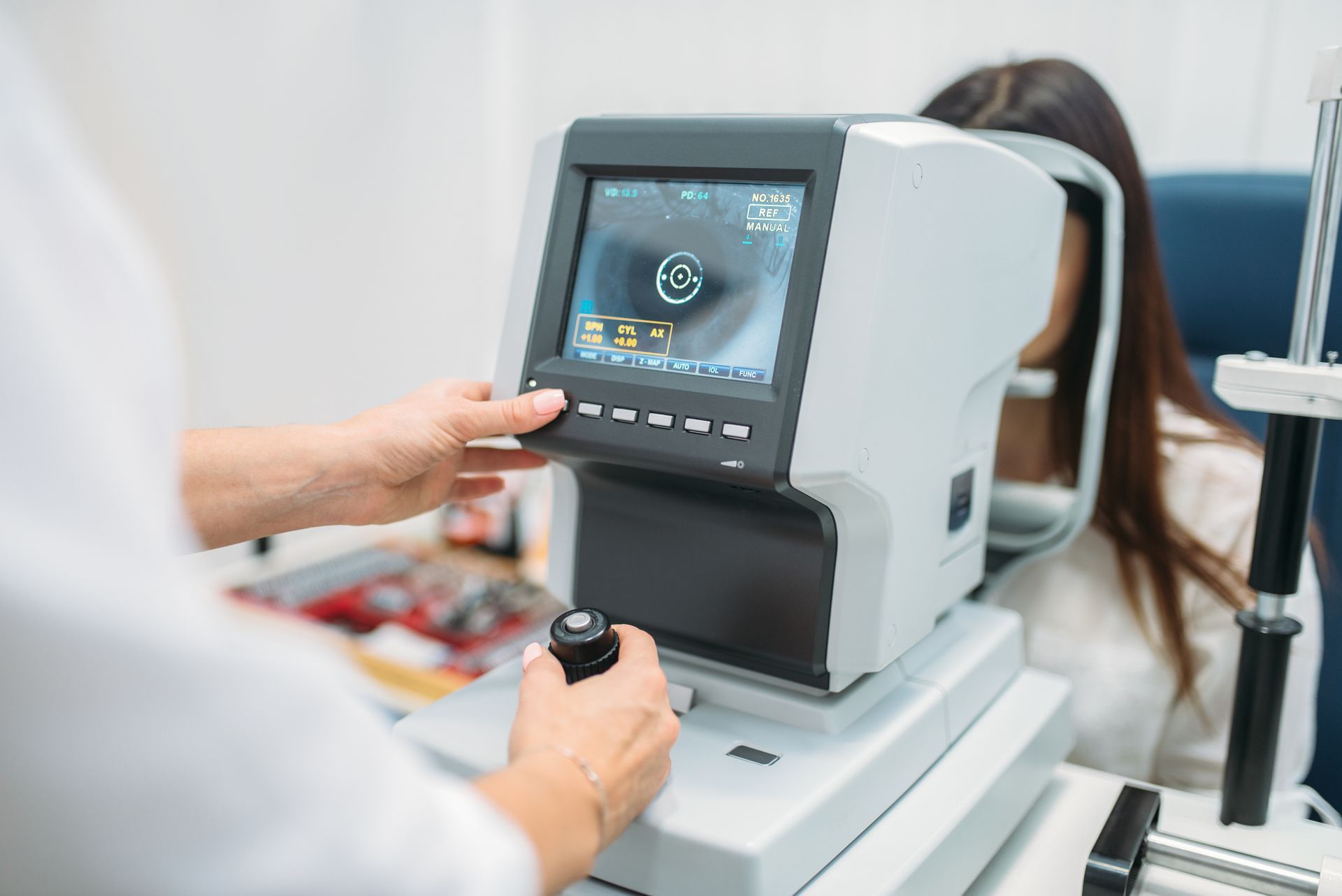 Medical imaging technician operating a handheld controller beside a diagnostic scan machine