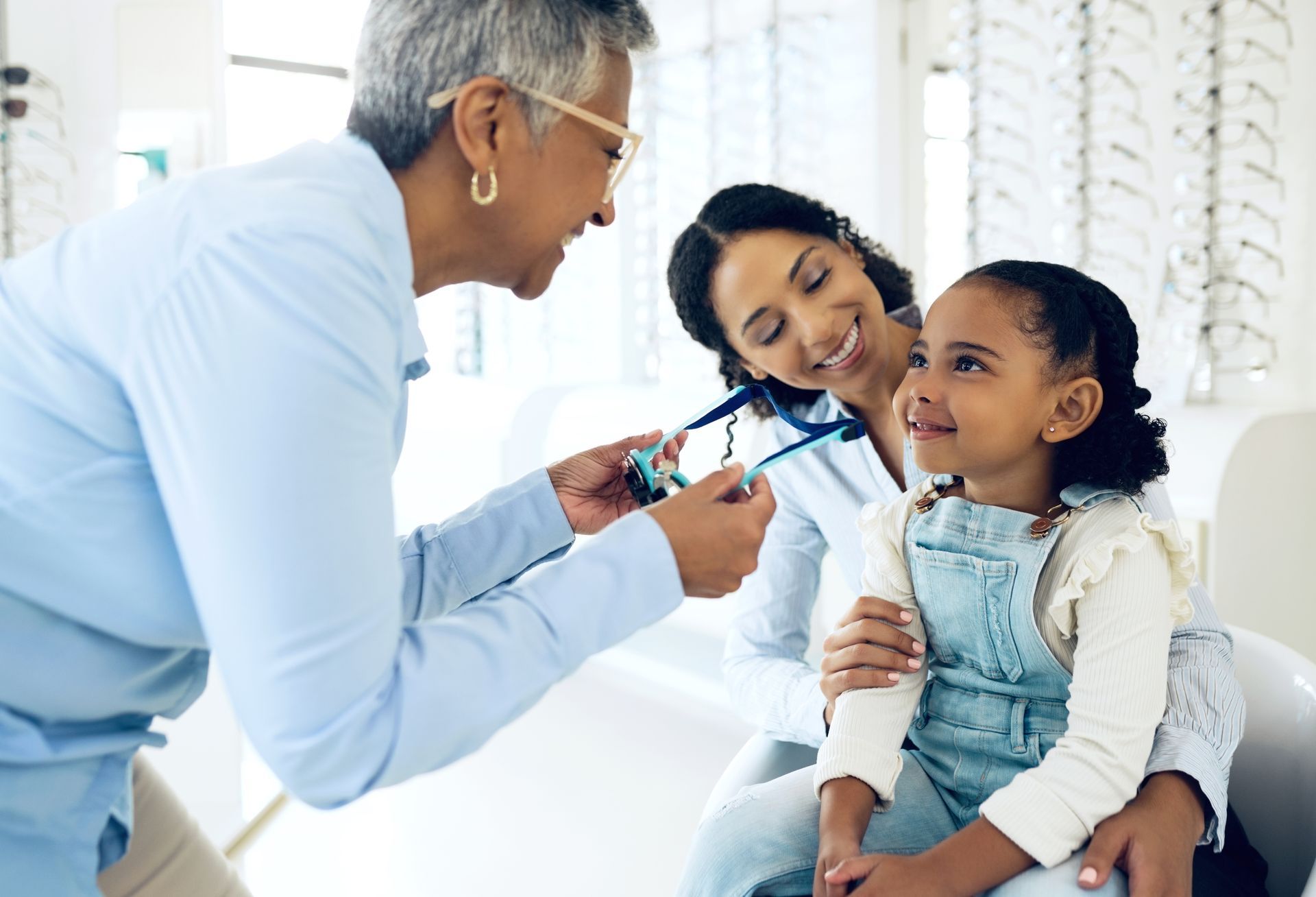 Doctor examining a smiling child while a parent watches in a bright clinic Doctor examining a smiling child while a parent watches in a bright practice
