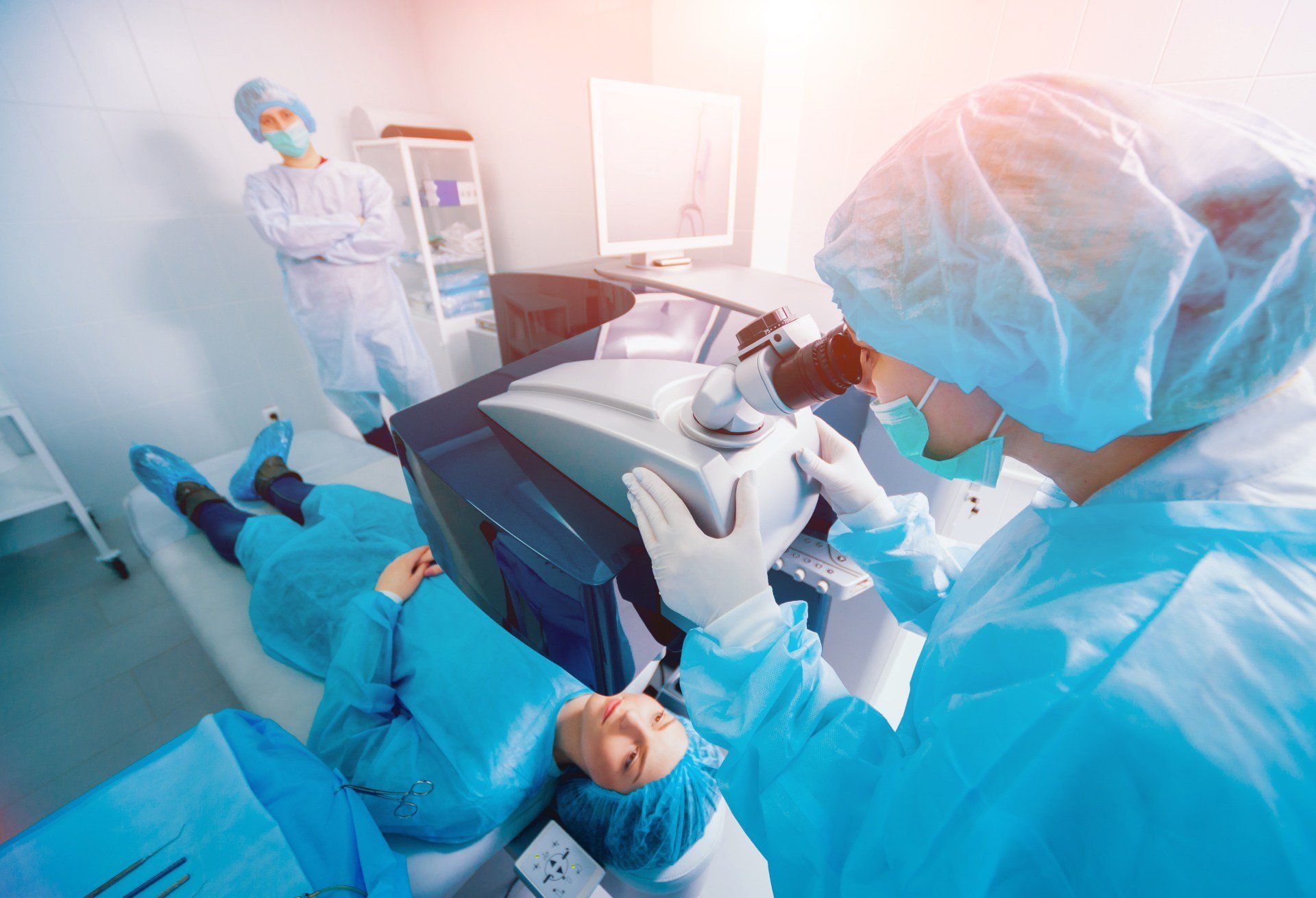 Un dentista visita un paziente in una clinica luminosa, indossando una tuta protettiva blu e utilizzando attrezzature odontoiatriche.