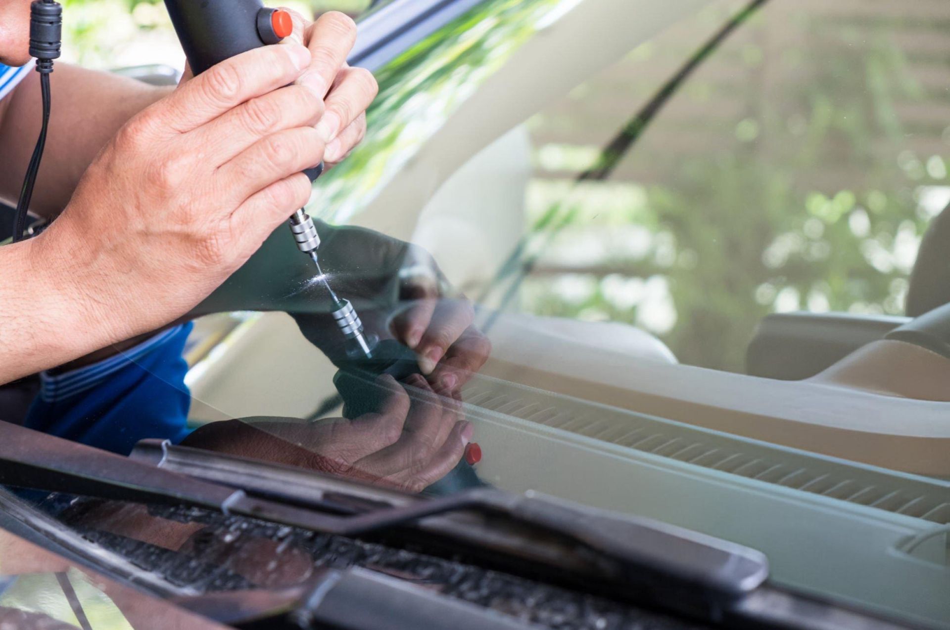A person using a screwdriver to fix a windshield