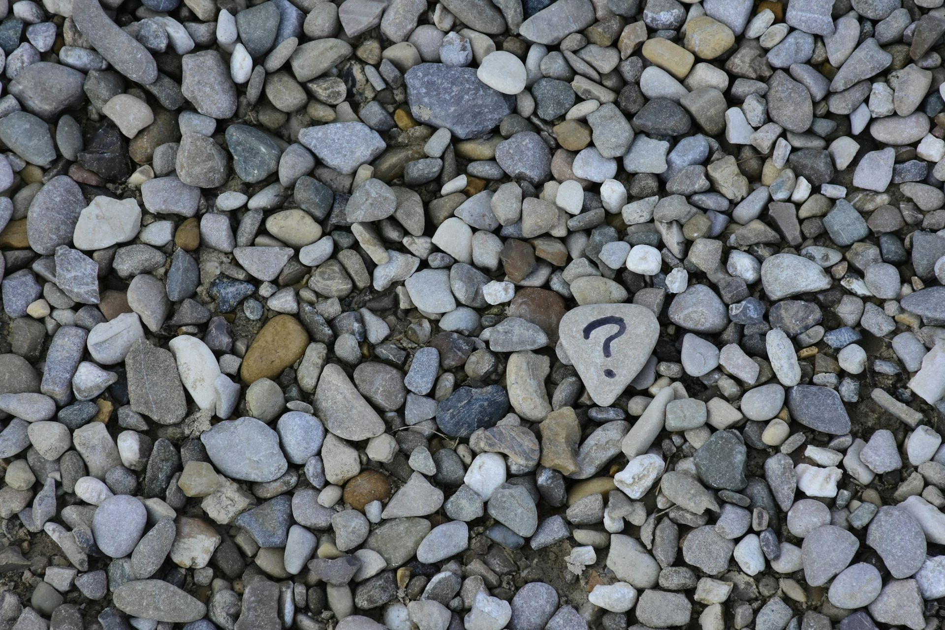 A pile of rocks with a question mark in the middle