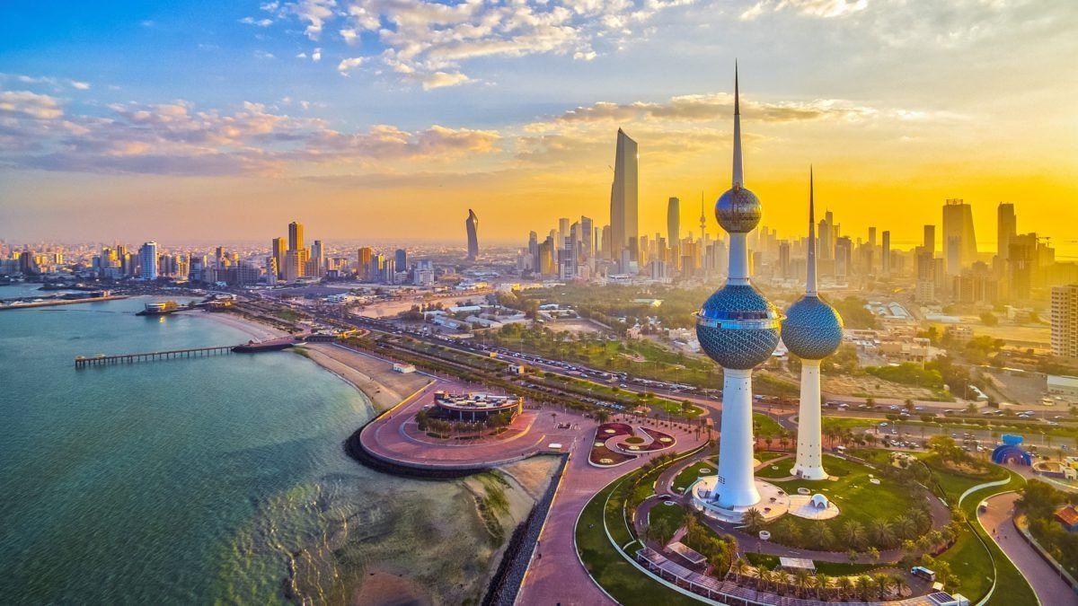 An aerial view of the city skyline of kuwait at sunset.
