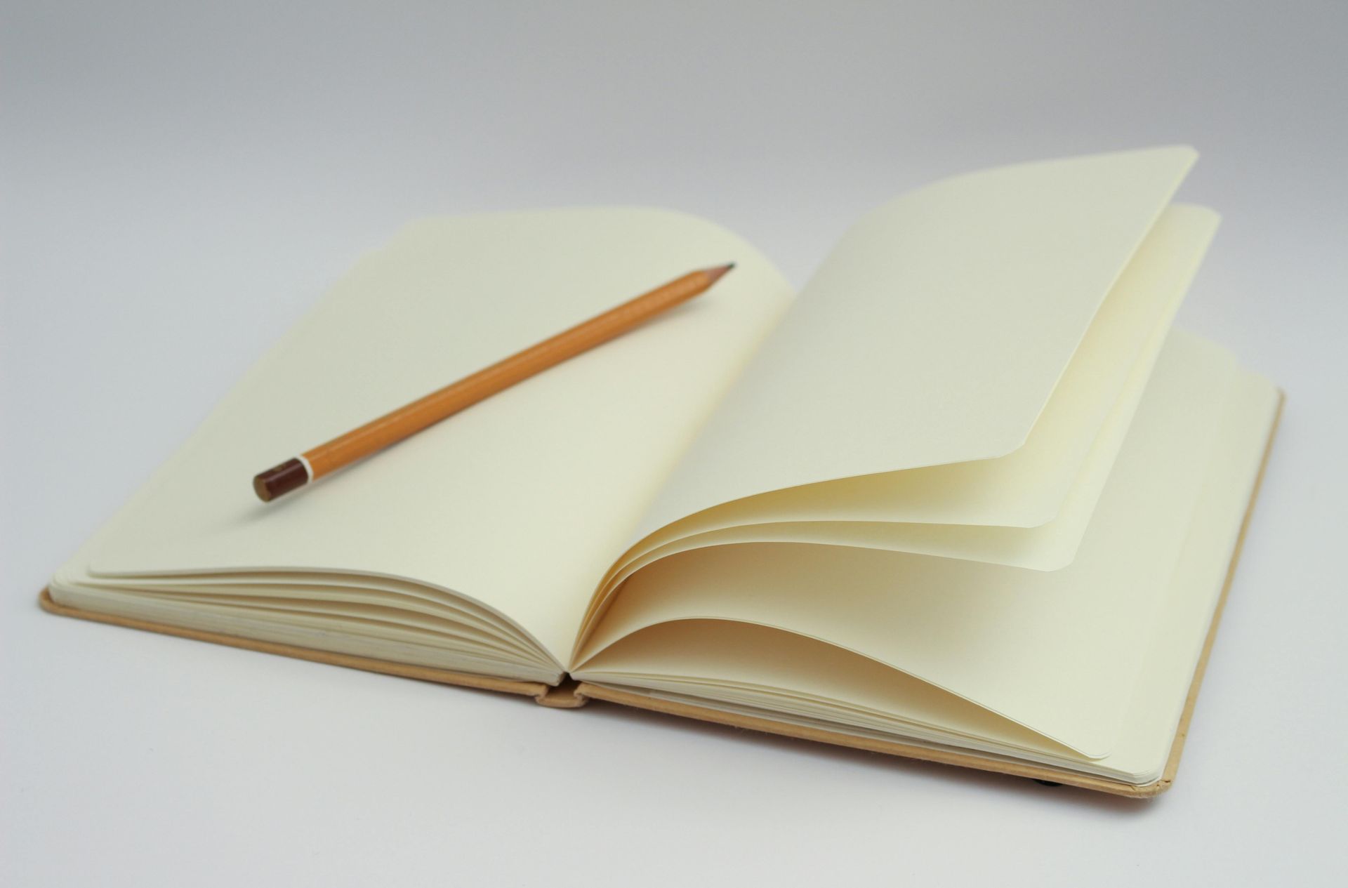An open notebook with a pencil on top of it