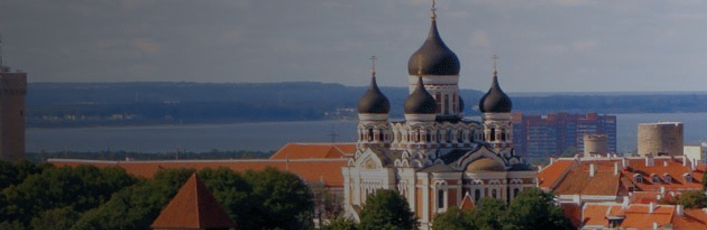 Panoramic cityscape with a domed cathedral by the river at sunset