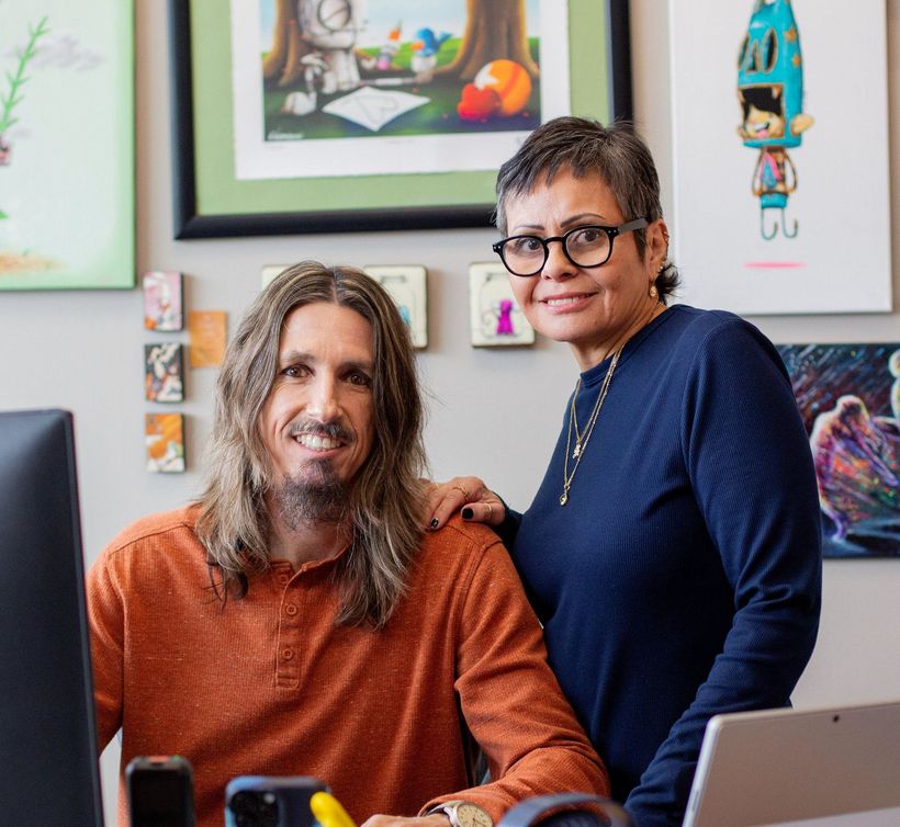 Brian and Julissa Ricks smiling in their office.
