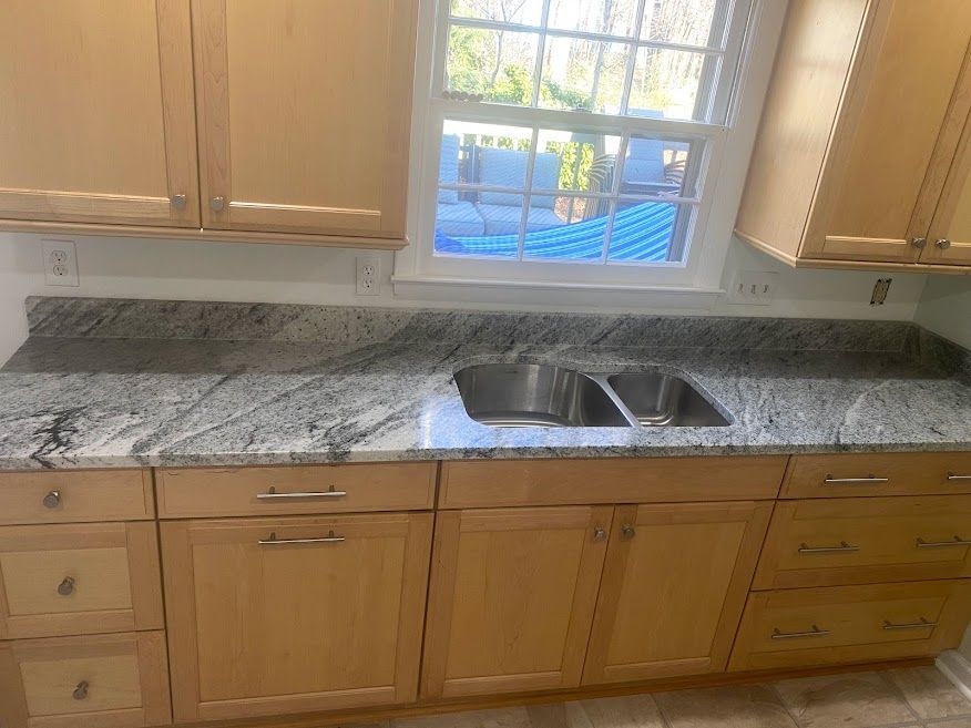 A kitchen with granite counter tops and stainless steel sink.