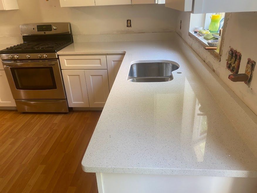 A kitchen with white cabinets and a stove and sink