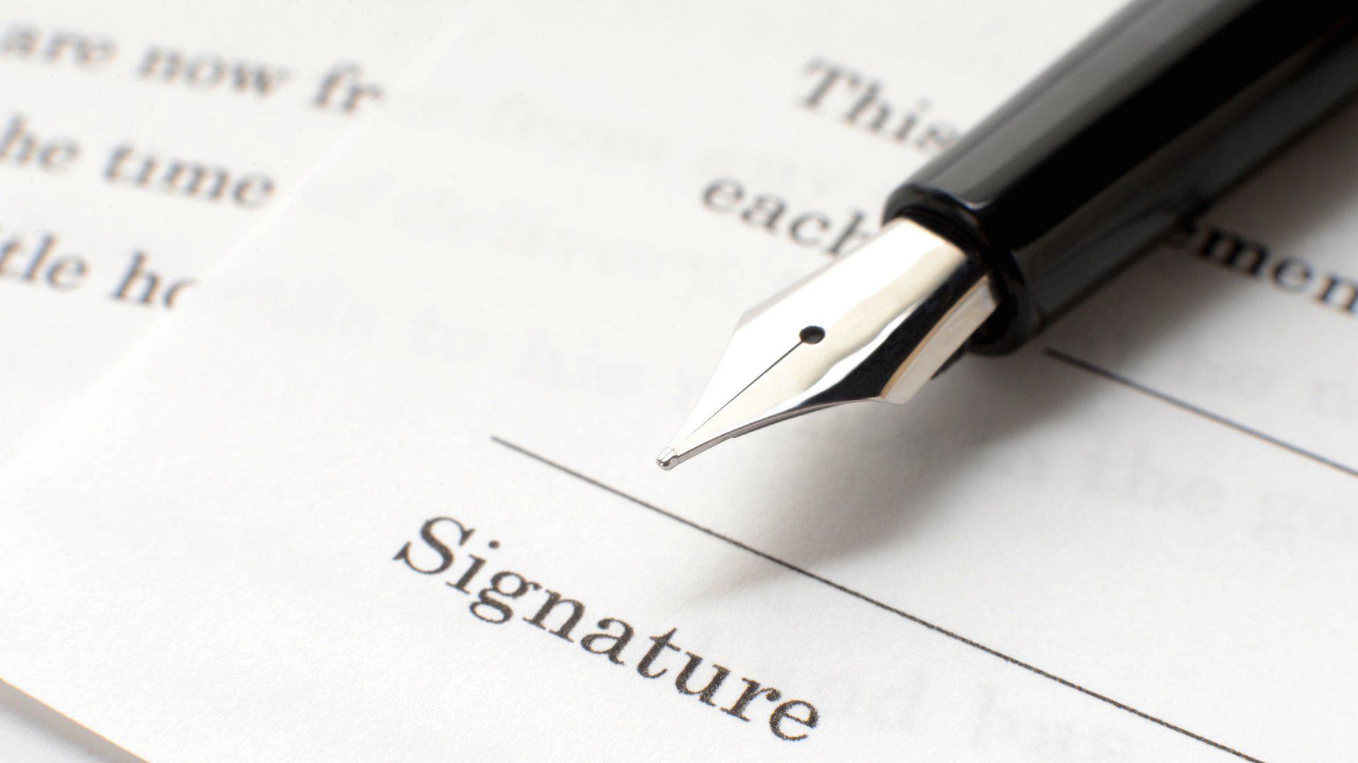 Fountain pen resting on the signature line of a contract