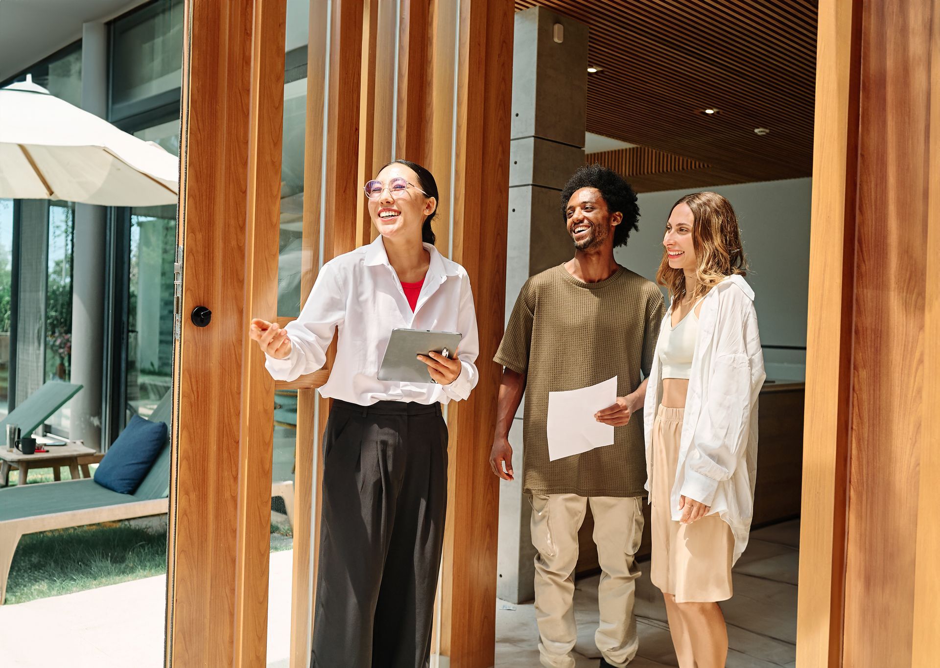 Three coworkers chatting and smiling outside a modern office building