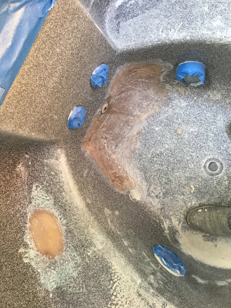 Close-up of a worn metal surface with several blue fasteners and a small orange stain.