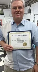 Man holding a certificate from a grooming school, smiling in a shop setting.