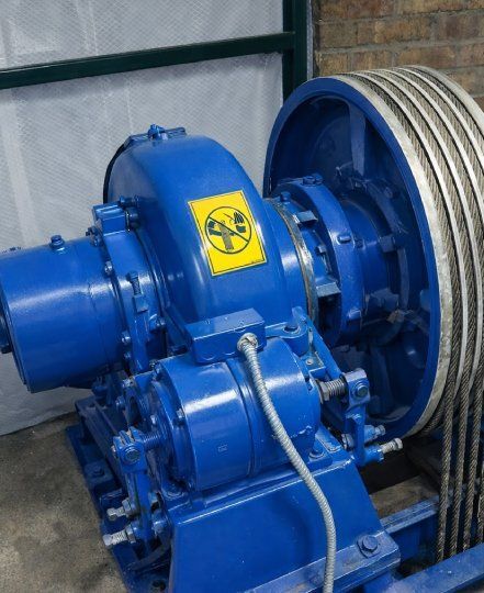 Industrial hoisting machine against weathered brick