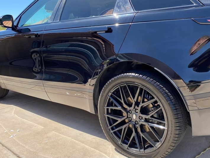 Black SUV side view with chrome trim and black alloy wheel parked on a sunny street