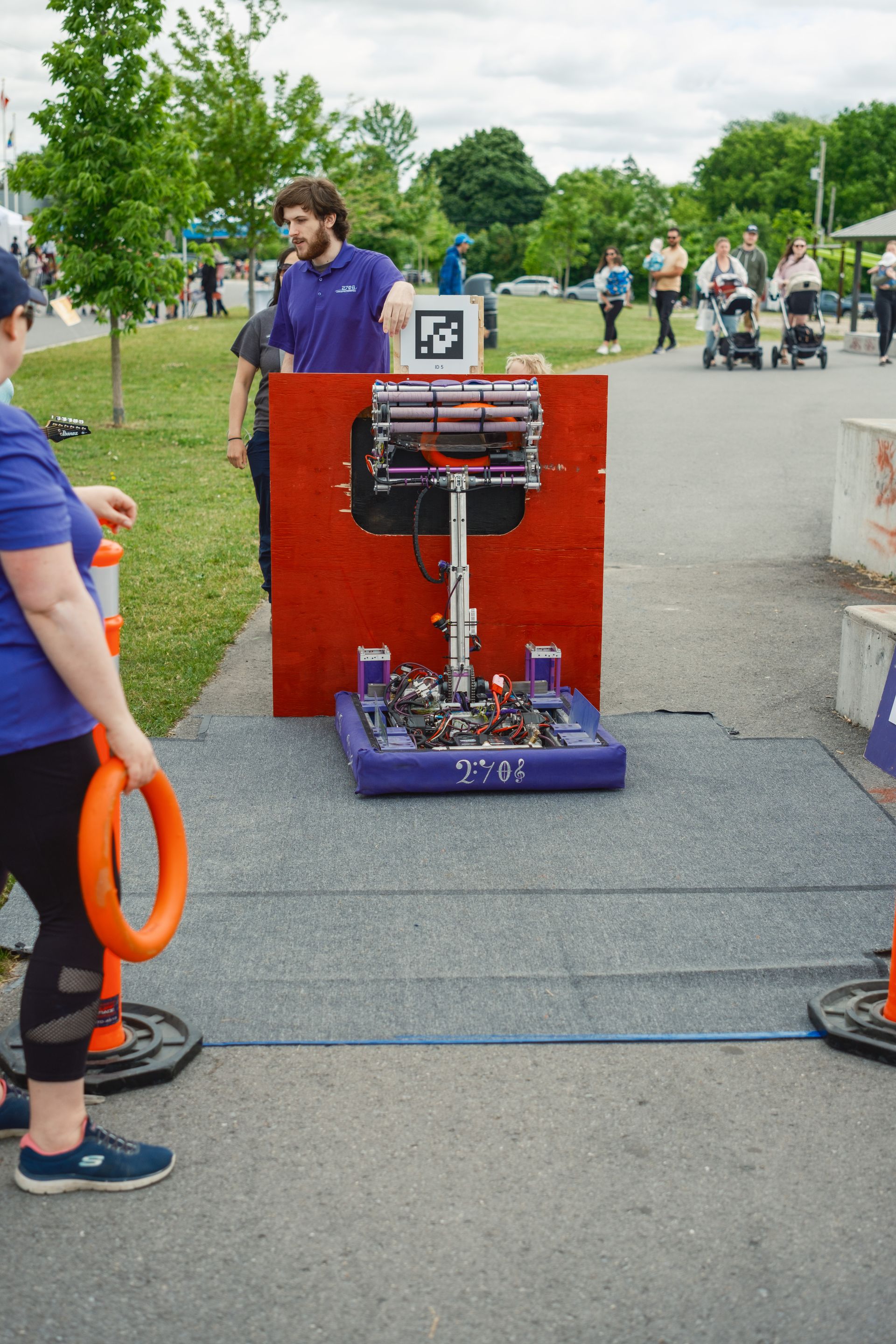 A woman is holding an orange ring in front of a machine.