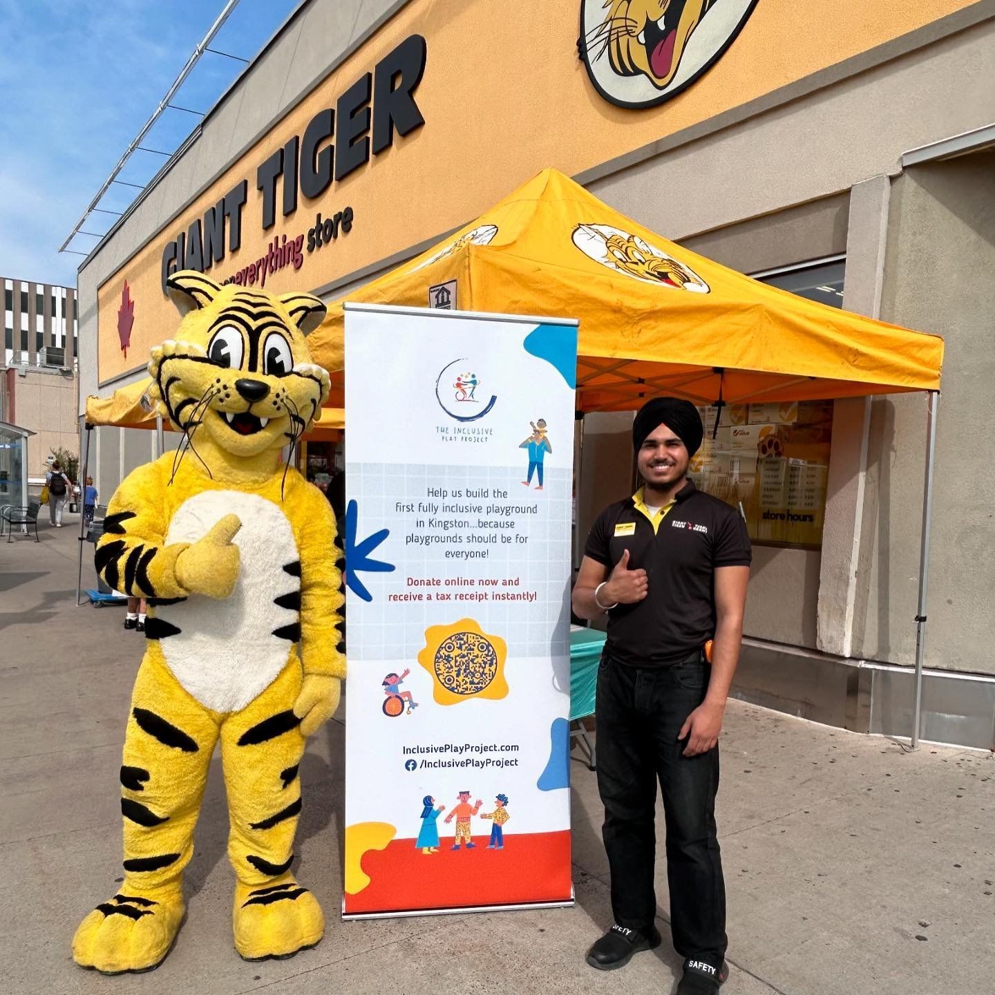 A man standing next to a tiger mascot in front of a paint tiger store