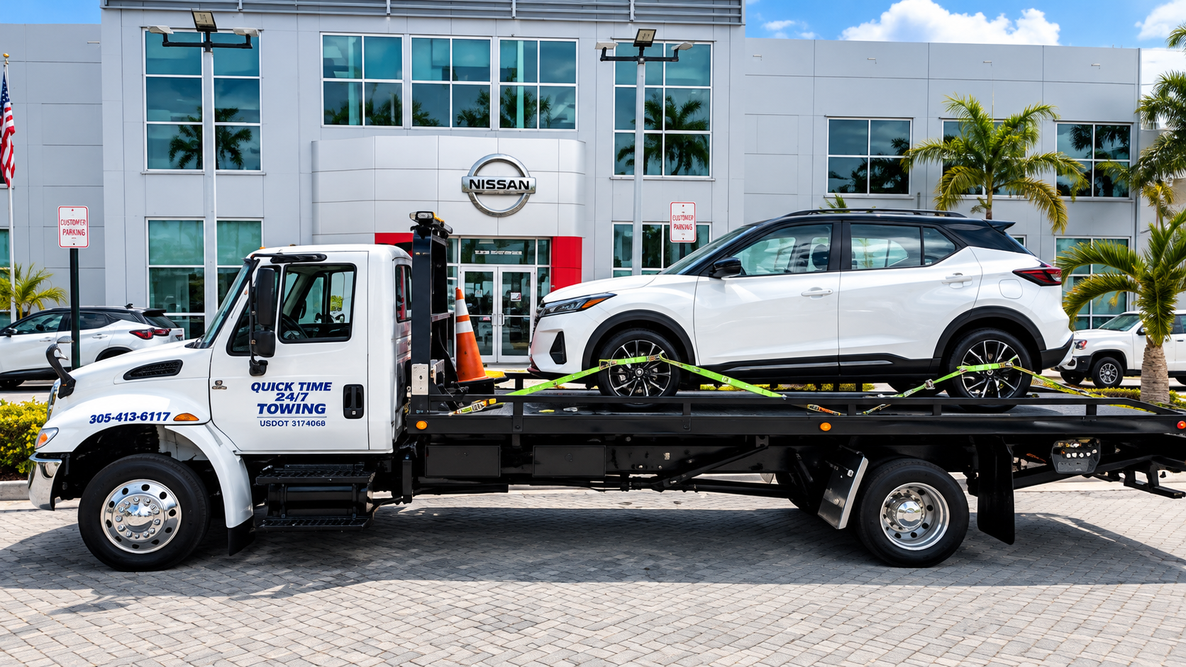 Tow truck carrying a white SUV in front of a car dealership building