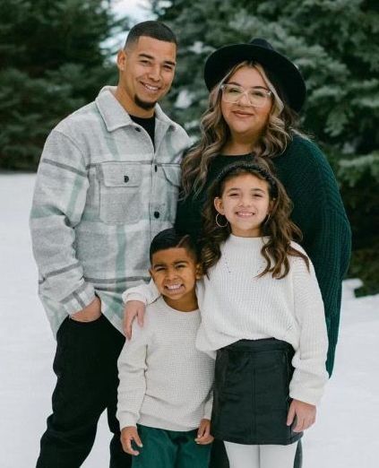 A family is posing for a picture in the snow.