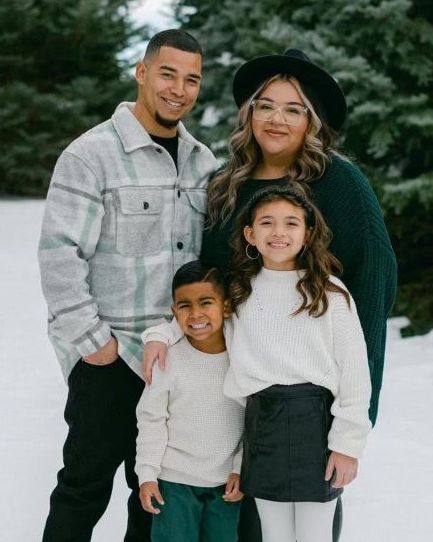 A family is posing for a picture in the snow.