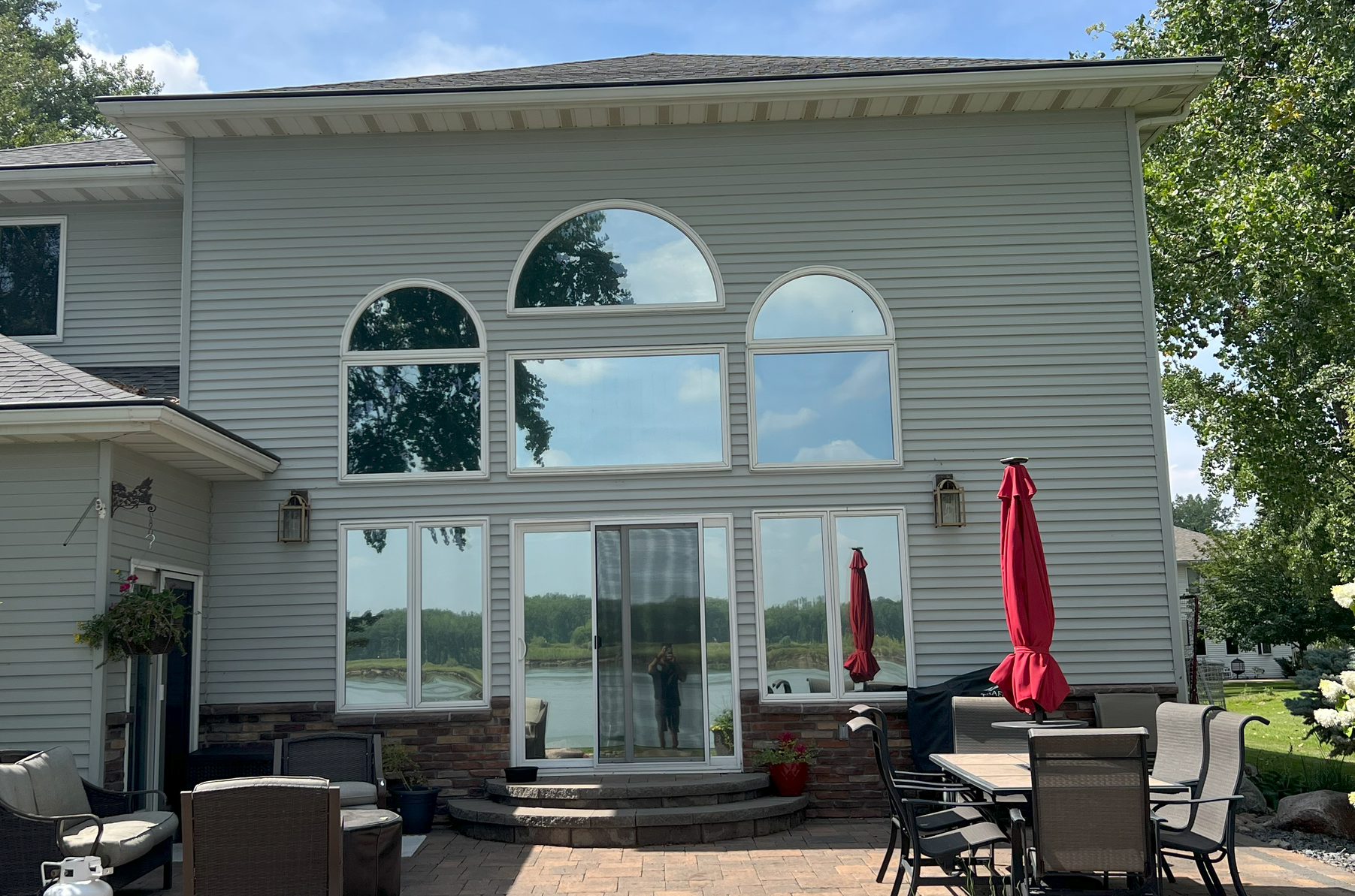 A large white house with a patio and a table and chairs in front of it.