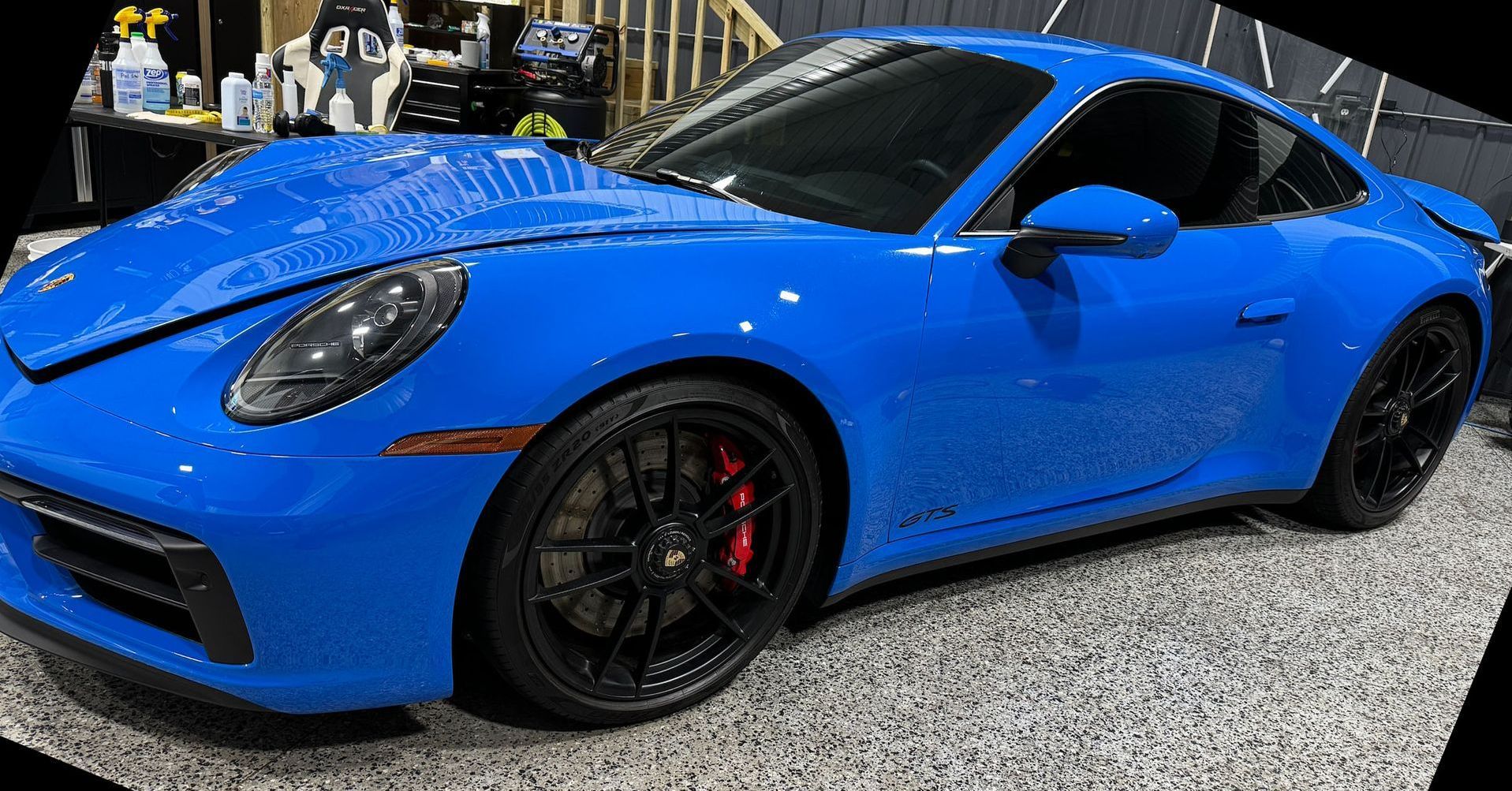 A blue porsche 911 gt3 is parked in a garage.