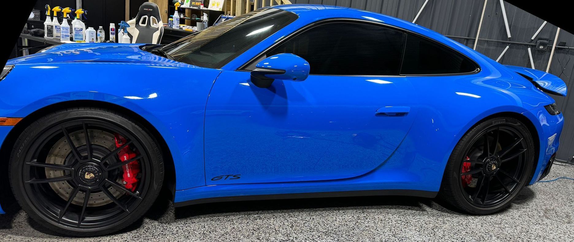 A blue porsche 911 gt3 is parked in a garage.