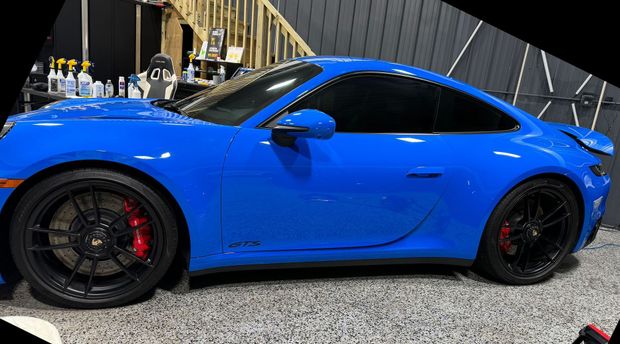 A blue porsche 911 gt3 is parked in a garage.