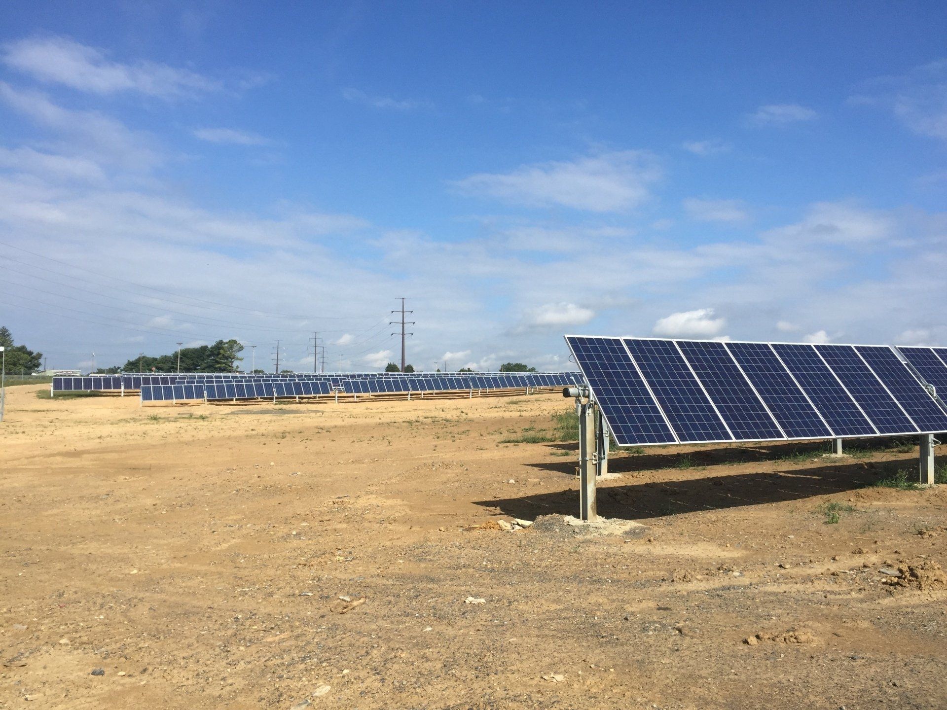 A field of solar panels on a sunny day