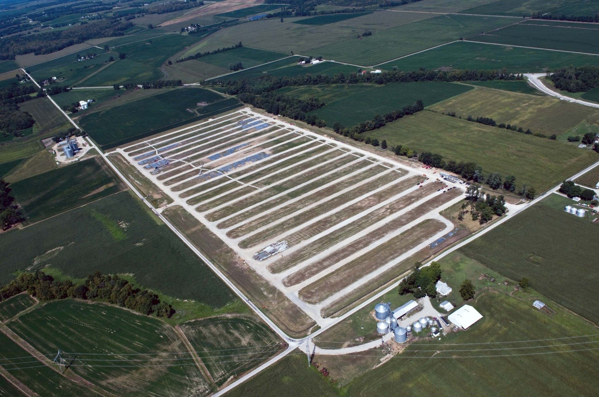 An aerial view of a large farm with lots of fields and trees.