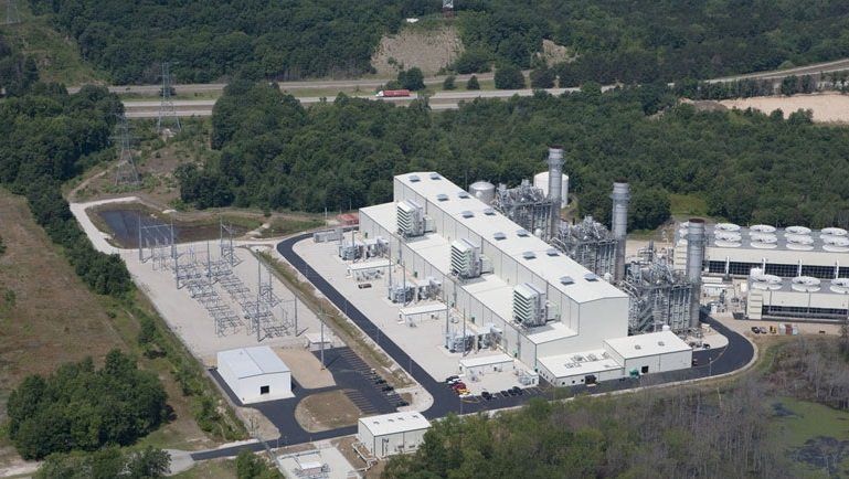 An aerial view of a large industrial plant surrounded by trees.