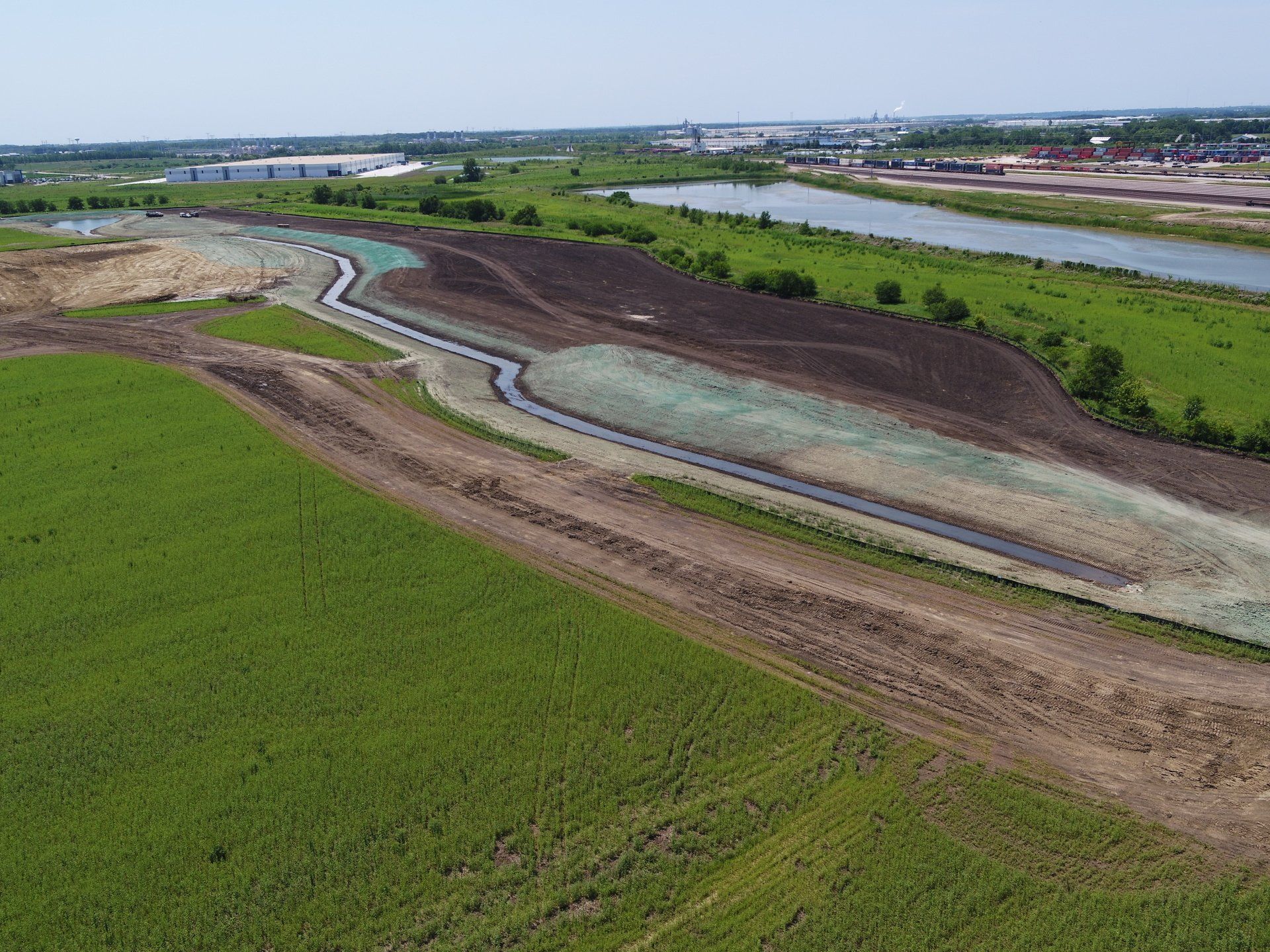 An aerial view of a river running through a lush green field.