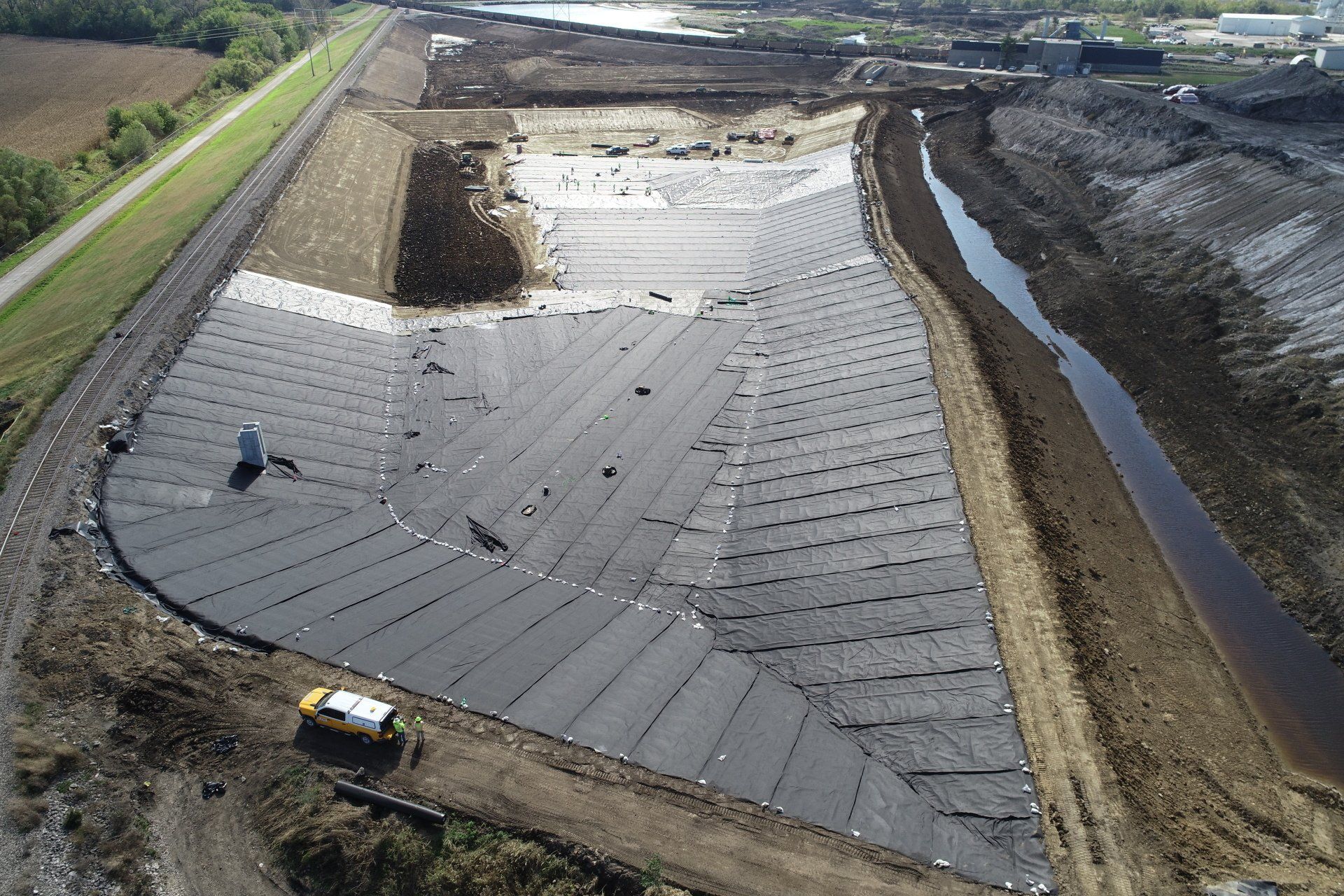 An aerial view of a construction site with a river in the background.