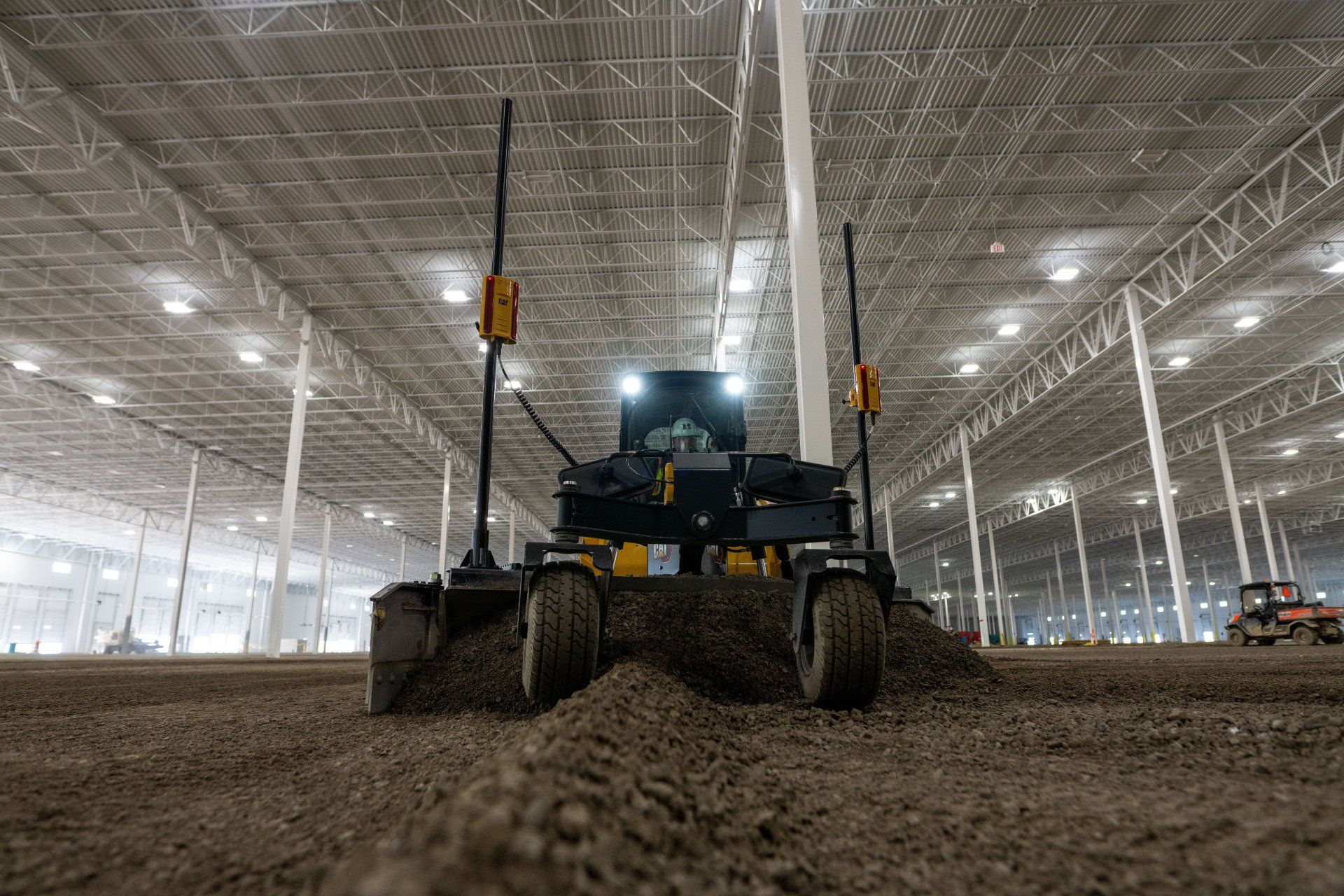 A robot is moving dirt in a large warehouse.