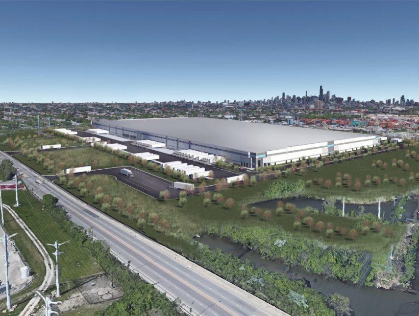 An aerial view of a large warehouse next to a river.