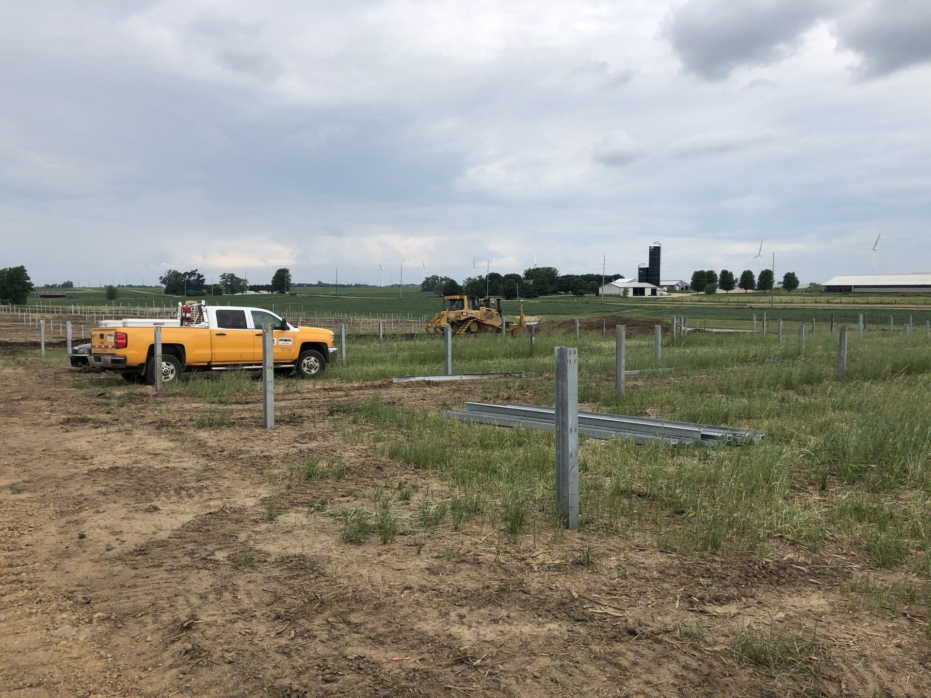 A yellow truck is parked in the middle of a field.