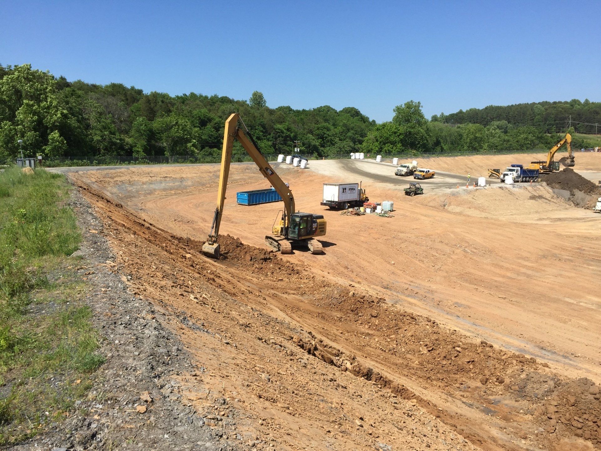 A construction site with a lot of dirt and trees in the background.