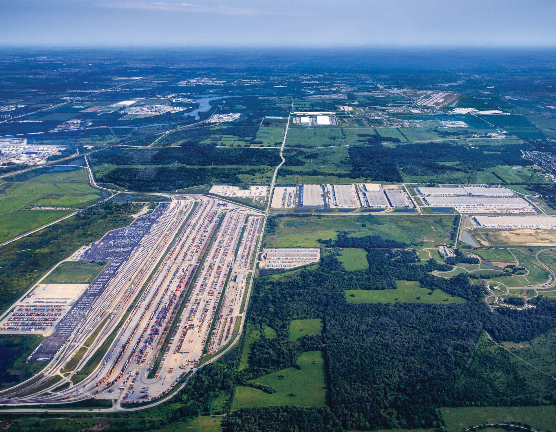 An aerial view of a large industrial area surrounded by trees and fields